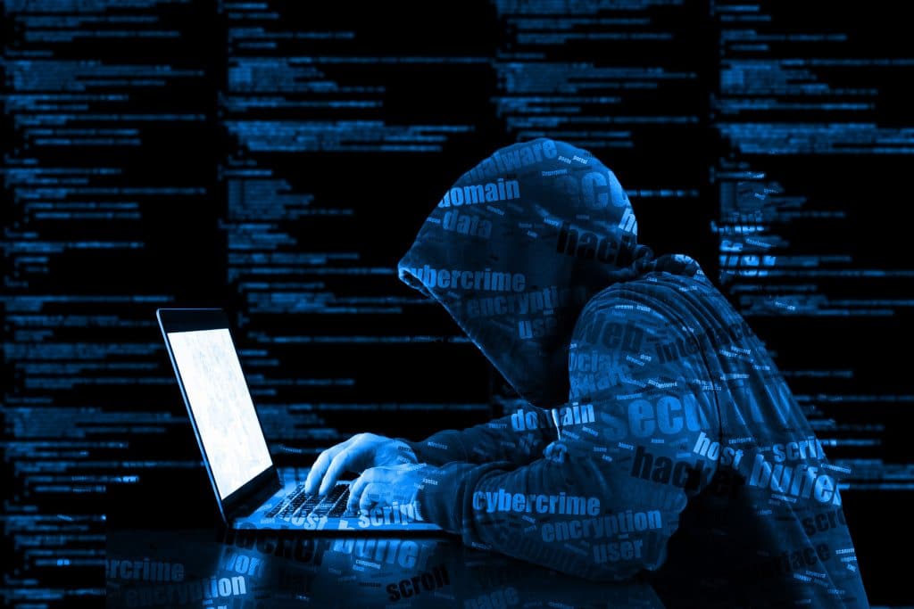 Symbolbild Hacking - Grafik: Person mit Kapuze sitzt vor Laptop