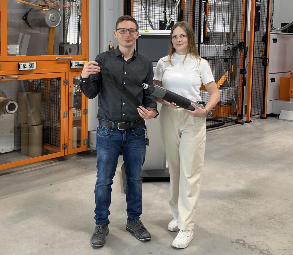 Andreas Kapshammer und Magdalena Huber von der JKU in Linz stehen nebeneinander mit dem Modell eines Hochdruckwasserstofftanks in der Hand