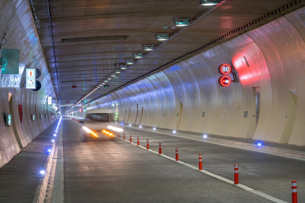 Blick in den beleuchteten Karawankentunnel zwischen K&auml;rnten und Slowenien, in dem ein Auto f&auml;hrt