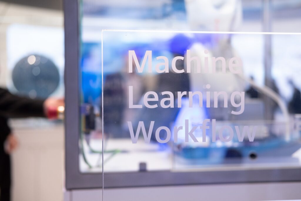 Detailansicht aus einem Forschungslabor von Siemens, durchsichtige Scheibe auf der "Machine Learning Workflow" steht